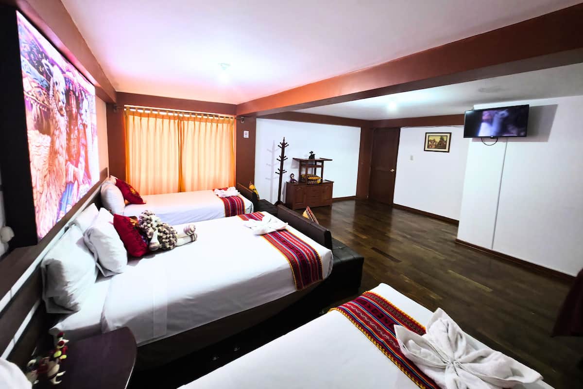 A hotel room with two beds, a television, a wooden cabinet, and a large painting on the wall.