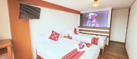 A hotel room with two beds, a TV, wooden flooring, and a staircase.