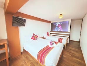 A hotel room with two beds, a TV, wooden flooring, and a staircase. - Mirador All Sur Cusco (Cusco)