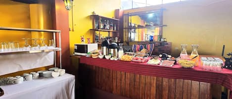 A breakfast buffet setup with various food items and glassware.