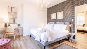 Een moderne slaapkamer met een bed, nachtkastjes, een bureau en een stoel.