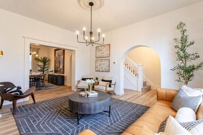 Un salon moderne avec une table basse ronde, un canapé et un escalier menant à un autre niveau.