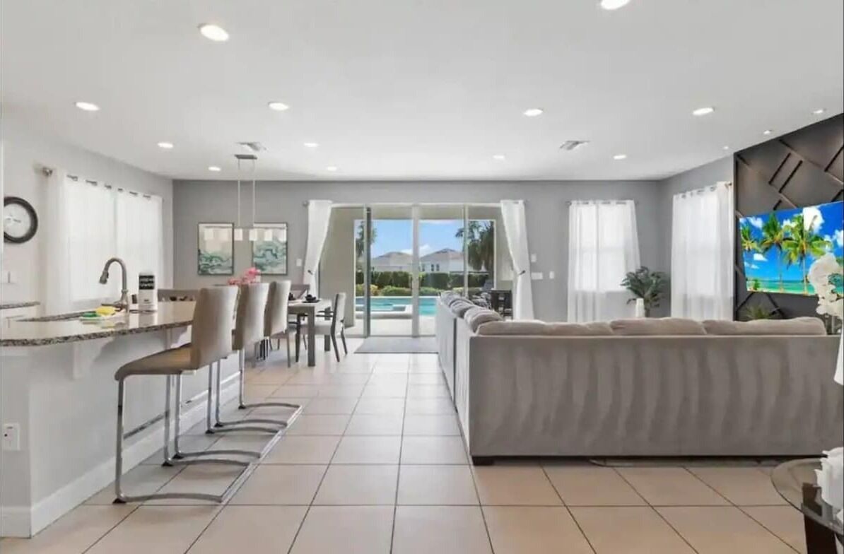 A modern living area with a kitchen, dining space, and a large sofa.