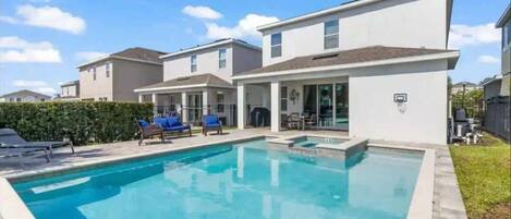 Um bairro residencial com piscina, casas e quadra de basquete.