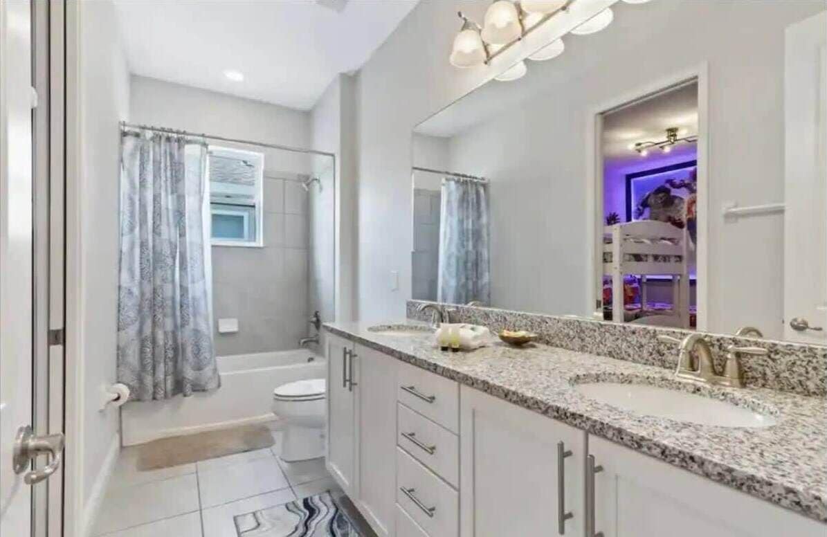 Un baño moderno con lavamanos doble, bañera y ducha.