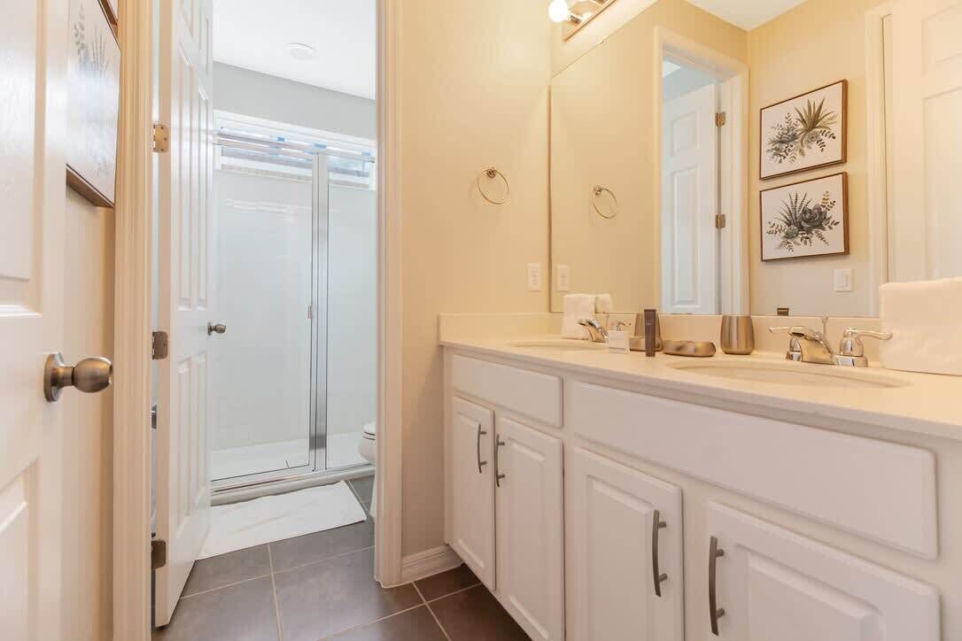 A bathroom with a shower, a sink, and a mirror.