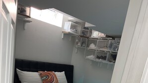 Une chambre à coucher avec un lit, un tapis bleu à poils longs et des étagères de rangement au-dessus du lit.