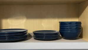 Een opslagkast met netjes gestapelde borden en kommen.