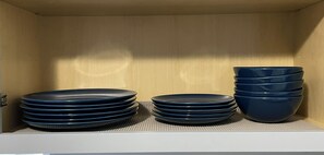 Ein Schrank mit ordentlich gestapelten Tellern und Schüsseln.