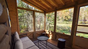 Eine Holzhütte mit einer Couch, einem kleinen Tisch und einem Mülleimer.
