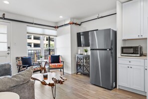 A compact living space with a kitchenette, a dining area with a table and chairs, and a sofa.