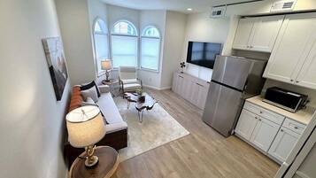 A modern apartment with a living room, kitchen, and dining area.