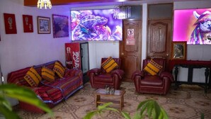 A living room with a sofa, two armchairs, a coffee table, a television, and a door with a sign. - Mirador All Sur Cusco - Santa Ana (Cusco)
