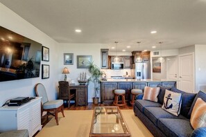 A modern living room with a sofa, coffee table, and a television. - Sea Gull #202LK: Beachfront 1 Bedroom 1 Bathroom With Spectacular Views and 24 Hour Management (Port Aransas)
