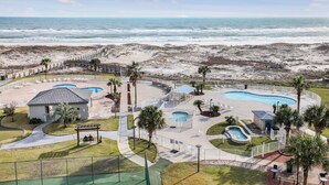 Een resort met een zwembad, een klein gebouw en uitzicht op het strand.