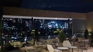 Eine moderne Lounge-Bereich im Freien mit Sitzgelegenheiten und Blick auf die Stadt.