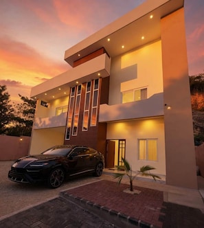 A modern two-story house with a car parked in the driveway.