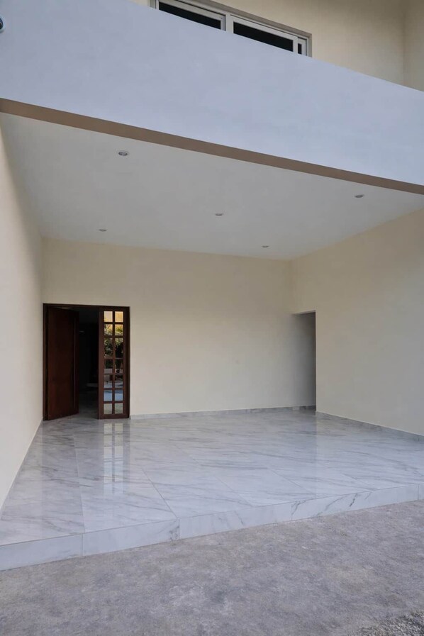 A spacious indoor area with a high ceiling and a marble floor.