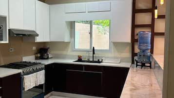 Eine moderne Küche mit Backofen, Spüle und einem Fenster für natürliches Licht.