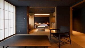 Une chambre d’hôtel moderne, équipée d’un lit, d’une chaise et offrant une vue à travers une porte coulissante.