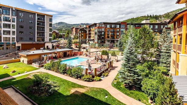 A resort with a swimming pool, multiple buildings, and a mountainous backdrop. - Sundial C302 | Ski-in/Ski-out | Fireplace | Mountain Views | Pool & Hot Tubs (Park City)