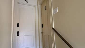 A hallway with two doors, numbered 4 and 5, and a wooden handrail.