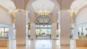 A spacious lobby with high ceilings, marble columns, and a central chandelier. - Cabo San Lucas oceanfront getaway with resort amenities (Cabo San Lucas)