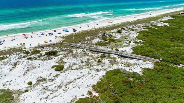 A beach with a wooden boardwalk, white sand, and green vegetation. - 🎥 Outdoor Movie Screen | Fire Pit | Games | Bikes | Sleeps 10 - Bike to Beach! (Inlet Beach)