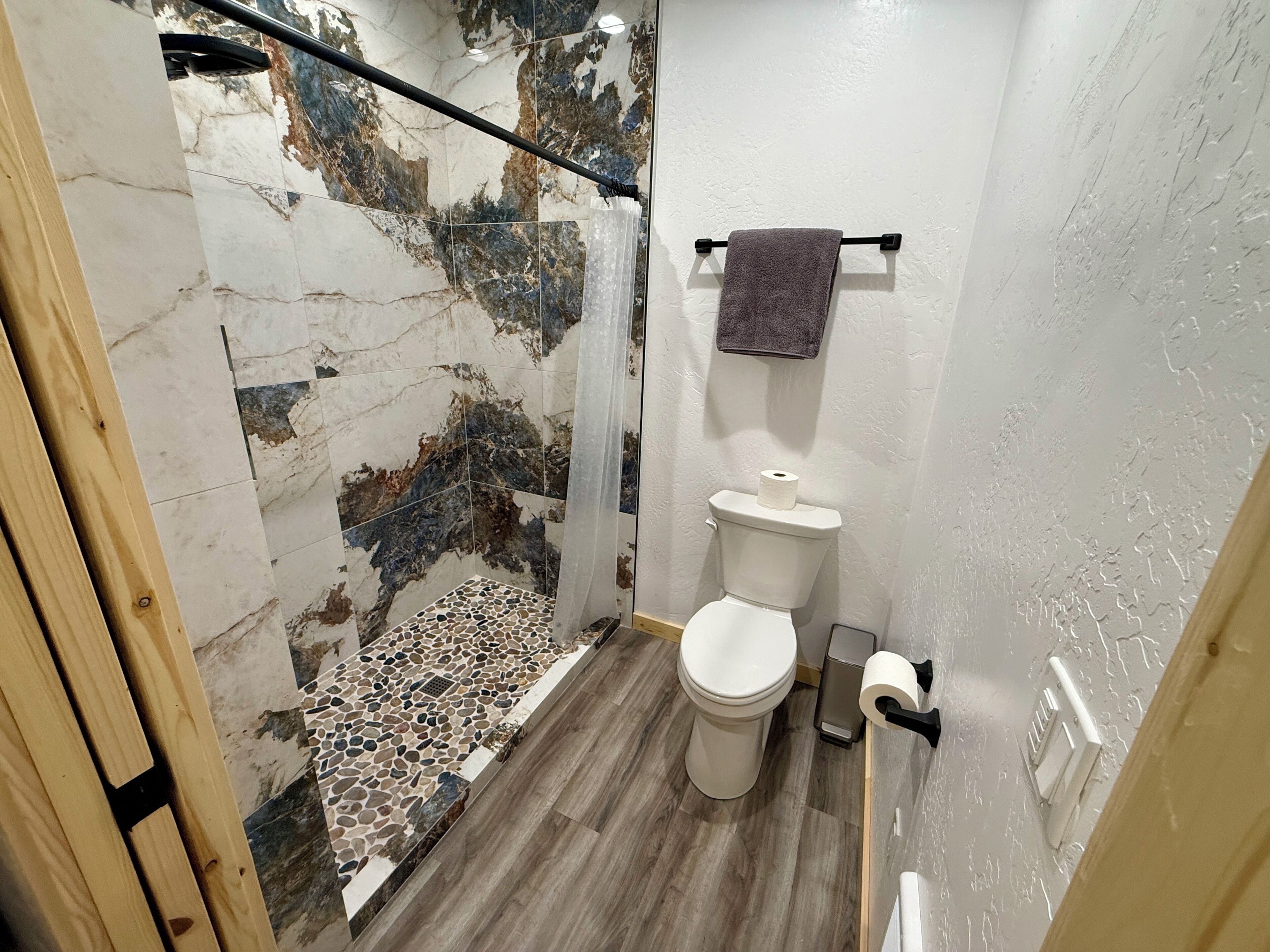 Een douche, handdoeken, zeep, toiletpapier
