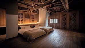 Ein Zimmer mit Holzböden, zwei Betten mit Kopfteilen, Holzvertäfelung und einem Fenster.