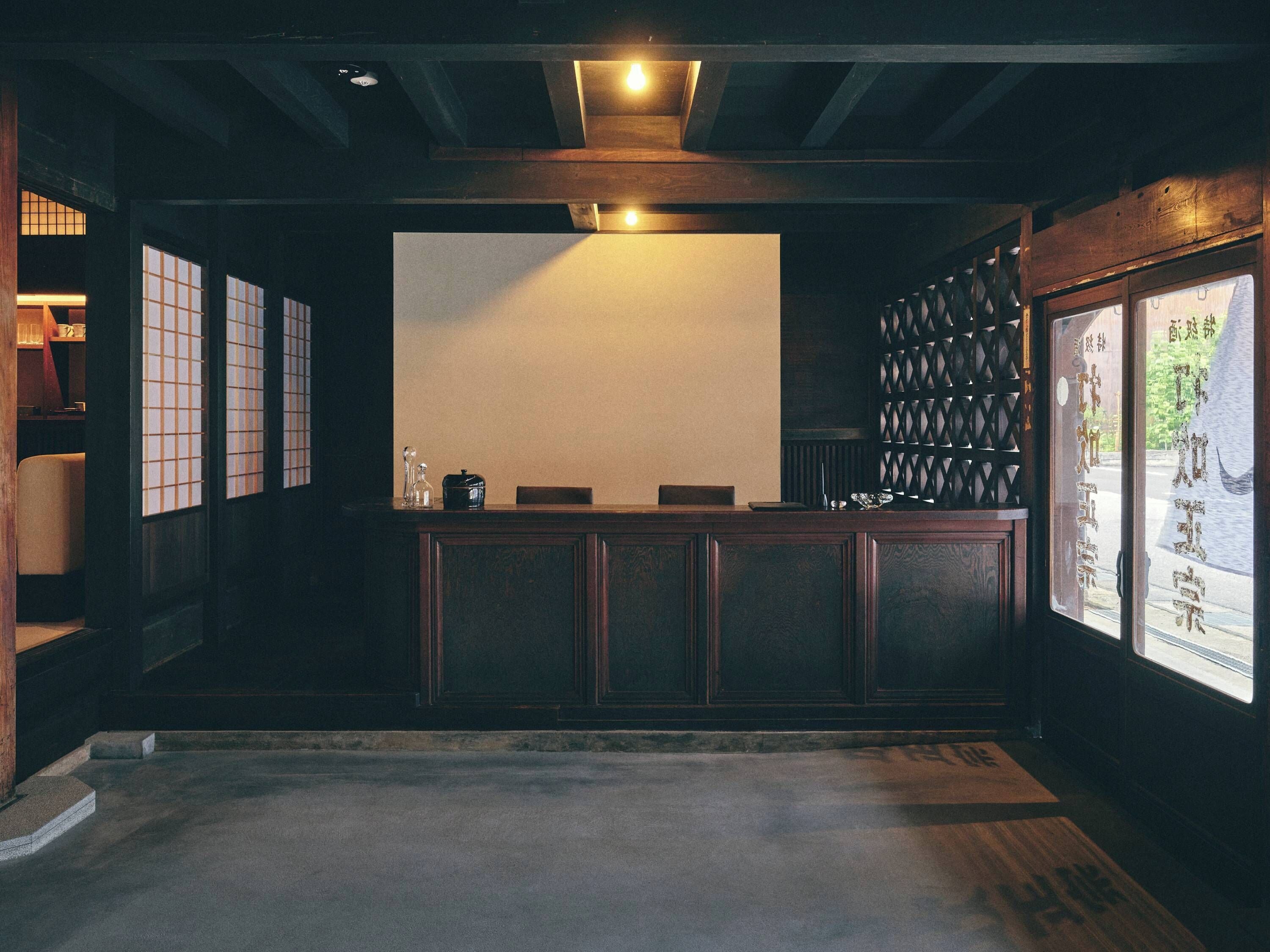 En traditionell japansk inredning med tatamimattor på golvet, en receptionsdisk och shojiskärmar.