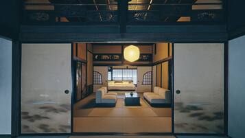 Una habitación tradicional japonesa con suelo de tatami, una mesa baja y una cama con futón.