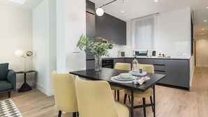 Een moderne keuken met een eethoek, een klein bijzettafeltje en een bank.