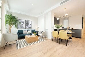 A modern living room with a sofa, coffee table, and dining area with chairs. - Doctor Castelo LXIII (Madrid)