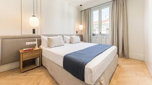 Ein Hotelzimmer mit einem großen Bett, Nachttischen und einem Fenster mit Vorhängen.
