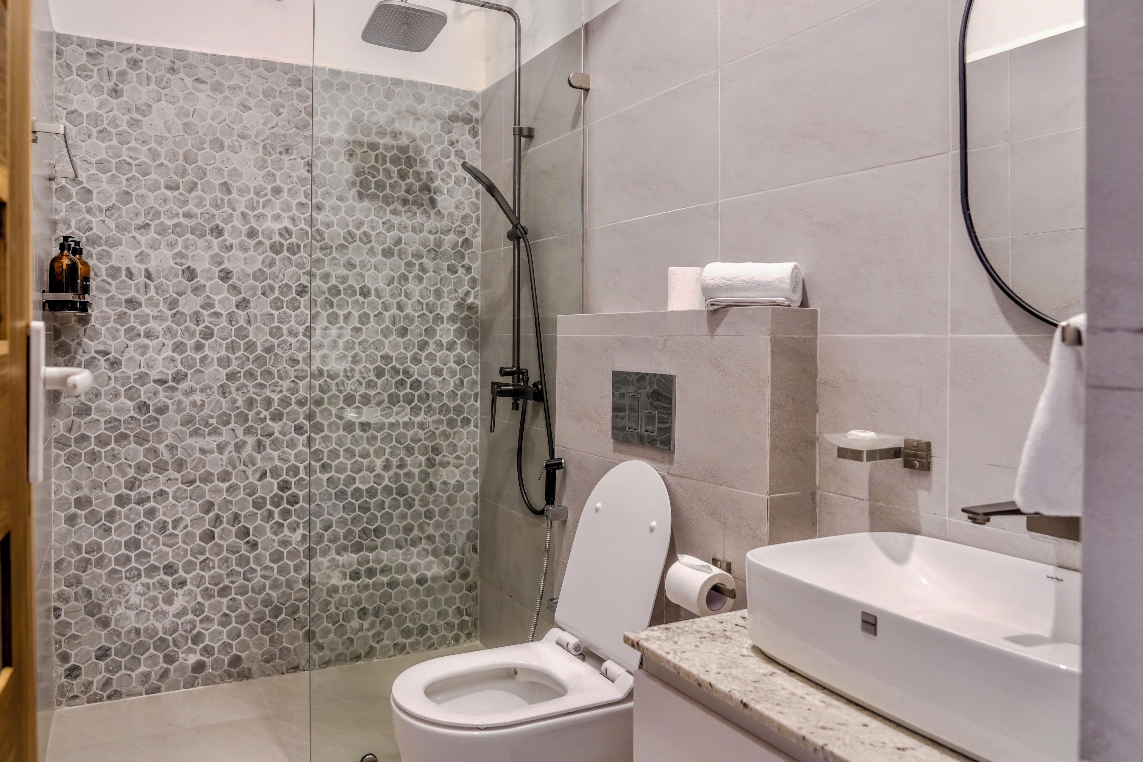 A bathroom with a shower, toilet, and sink.
