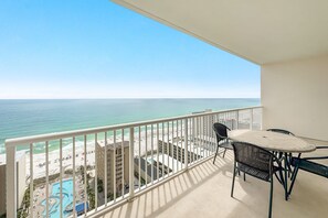 A balcony with a view of the ocean, a pool, and a building with multiple floors. - Beach View Top Floor Condo | Skywalk Beach Access | Pools | Sleeps 6 | BEACHBALL PROPERTIES (Gulf Shores)