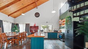 Un'ampia cucina con isola centrale, tavolo da pranzo in legno e sedie.