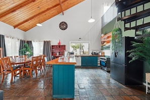 Una cocina amplia con una isla central, una mesa de comedor de madera y sillas.