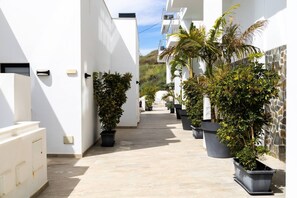 A narrow, paved pathway flanked by white buildings with potted plants. - Balcon del Mar - 2 bedroom - Nerja (Nerja)