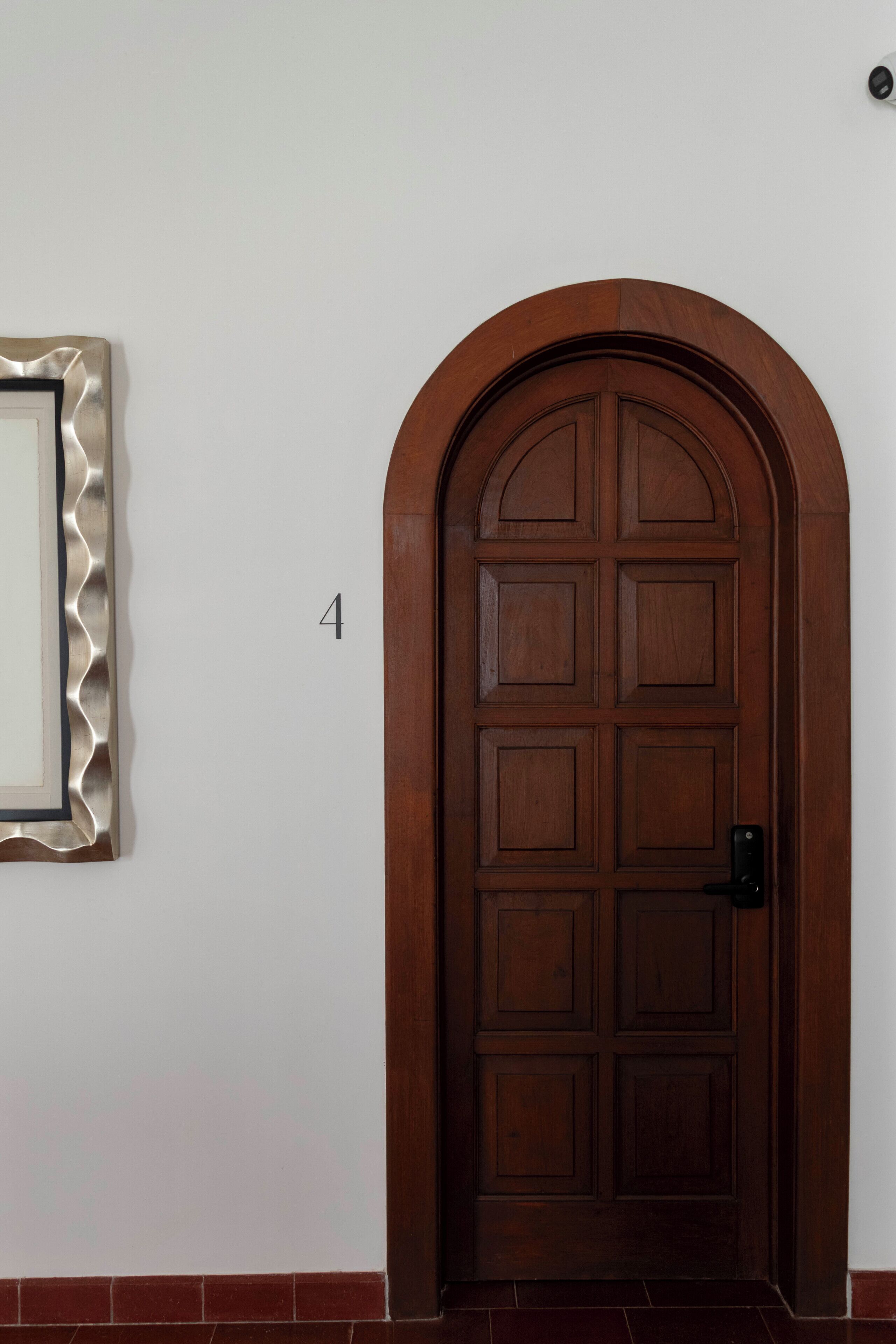 Eine Holztür mit der Aufschrift '1' an der danebenliegenden Wand.