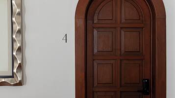 Eine Holztür mit der Aufschrift '1' an der danebenliegenden Wand.
