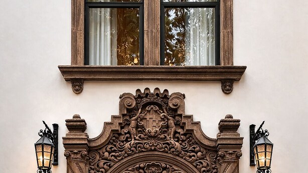 An ornate entrance with a decorative archway, a double door, and two wall-mounted lanterns. - Casa Lerma (Mexico City)