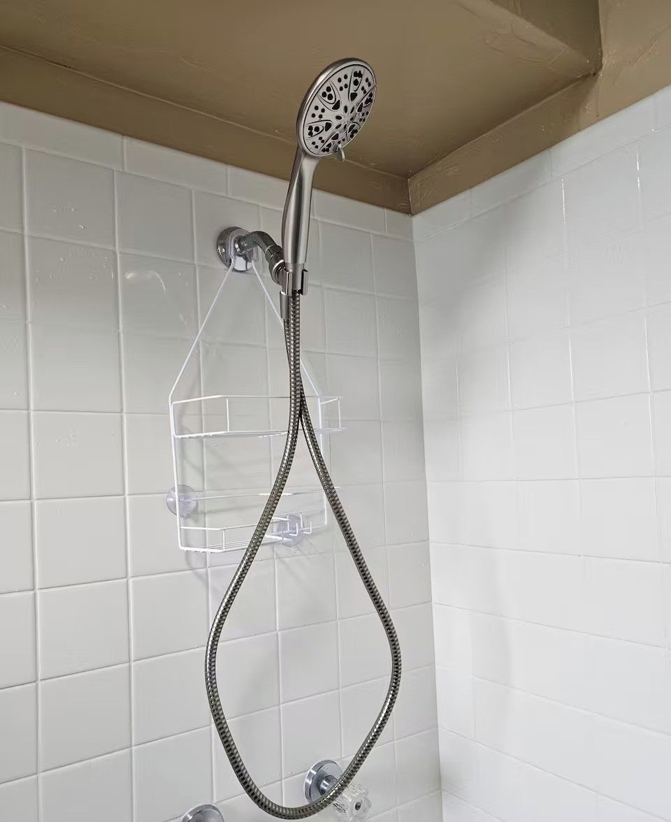 A shower with a handheld showerhead and a flexible hose.