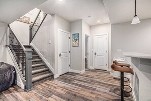 Eine Treppe mit Metallgeländer, Holzboden und einer Bar mit Hockern.