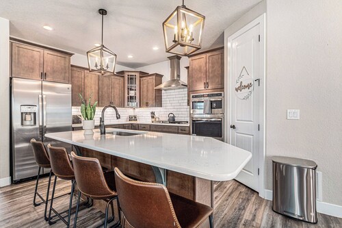 5 Bedroom house with amenities galore! Oversized hot tub, outdoor fire pit, smoker and propane grill, sauna, play set, espresso machine, air hockey table, indoor fireplace in both living rooms, and legacy bar.