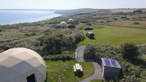 Un campamento con tiendas de forma abovedada, una mesa de picnic y un panel solar.