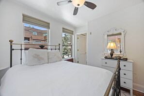 A bedroom with a bed, a dresser, a mirror, and a ceiling fan. - Ballard Bliss - Modern, Comfortable 3BR/3BA (Telluride)