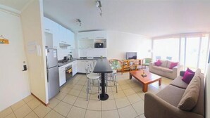 A compact living space with a kitchenette, dining area, and seating.