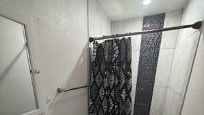Un baño con inodoro, lavabo y cortina de ducha.